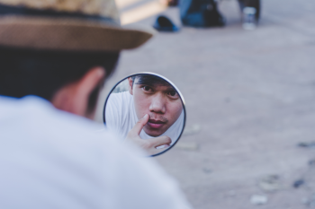 A man looking in the mirror at himself image